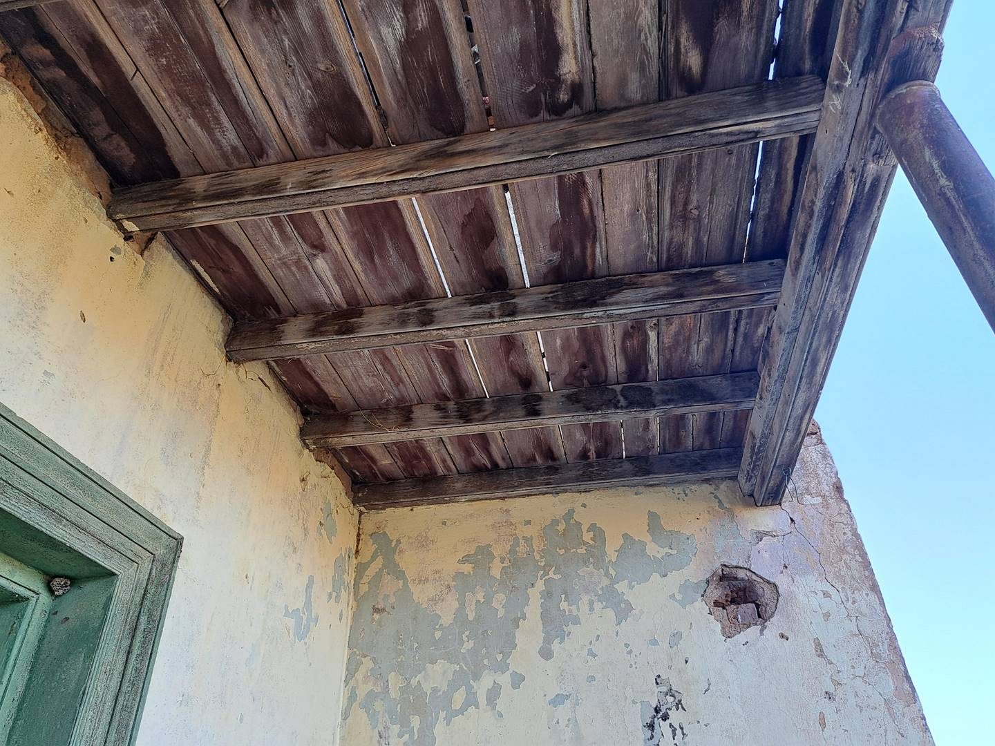 Decayed roof timbers and peeling paint at the old church before restoration